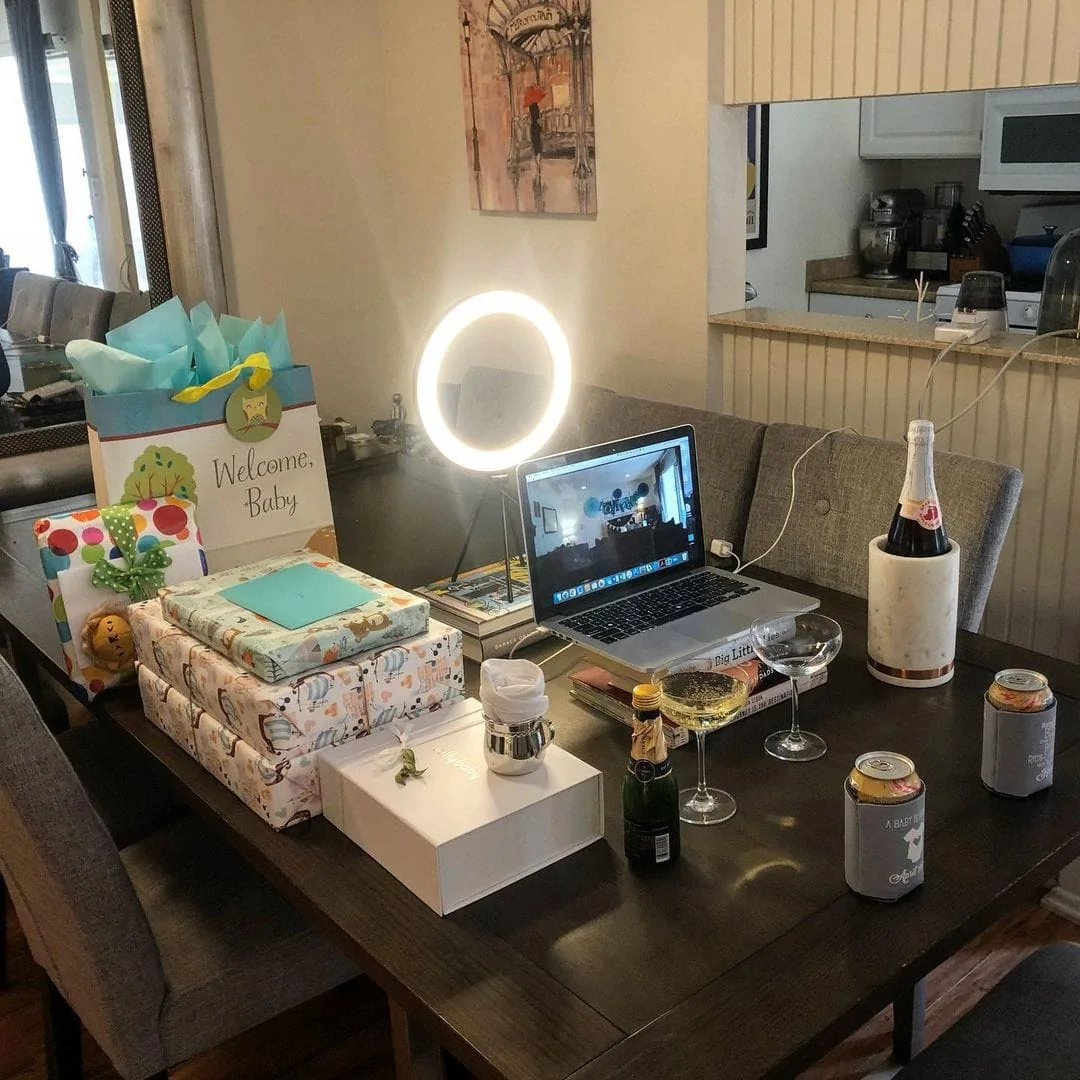 virtual baby shower laptop food and gifts on the table