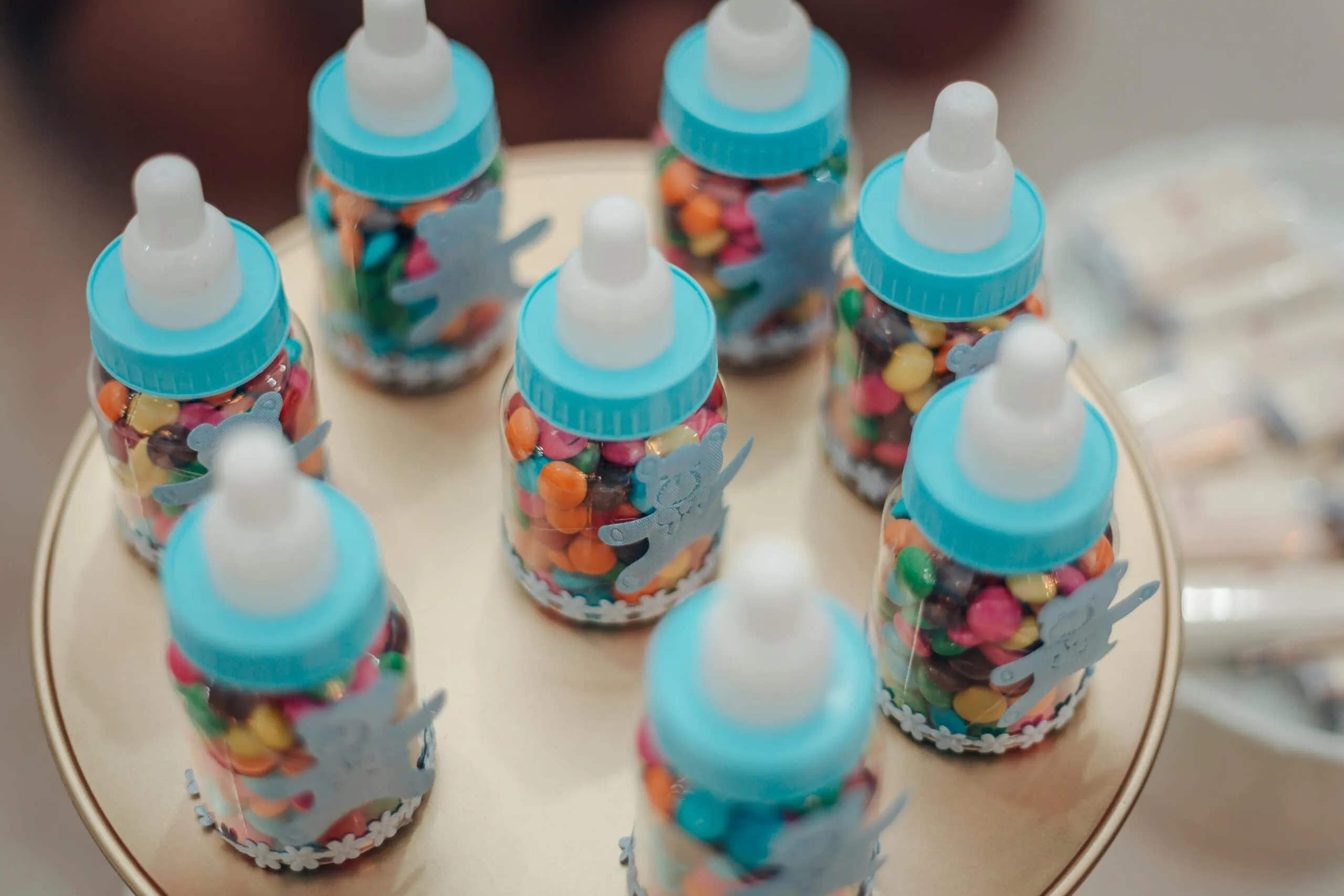 Close-up of colorful candies in baby bottles arranged for a festive occasion.